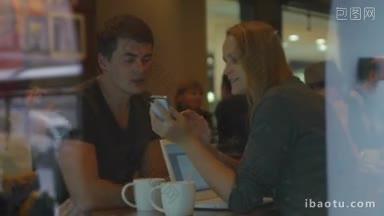 在咖啡馆街的茶歇时间，年轻男女一边用手机看东西，一边和人们讨论